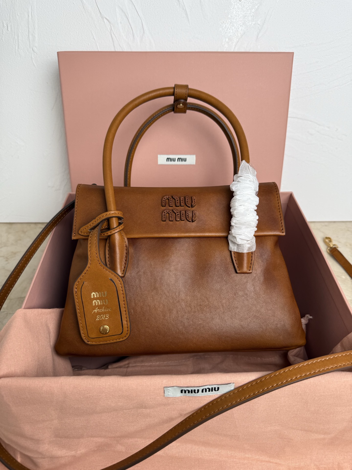 <p>miumiu新款小号</p><p>5BA303 MiMisolitaire新款小牛皮手袋 灵感源自06年档案 结构化线条与精致的细节 经典与实验相结合的优雅风格 独特的皮革纹理 复古与时尚的冲击 塑造独一无二的经典 正面标志性logo徽标 可拆卸挂饰与皮革长肩带 隔层多容量大</p><p>尺寸 23CM</p>