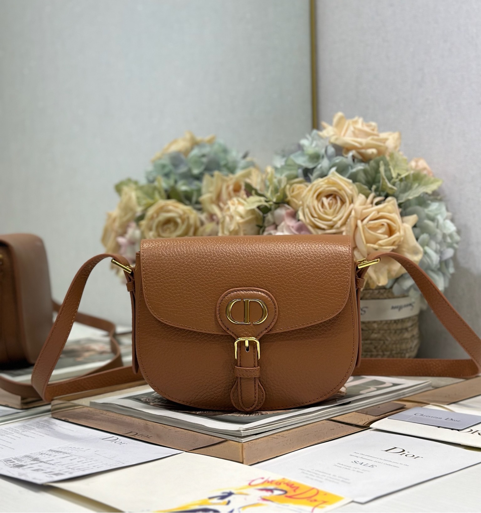 <p>New Dior Bobby 中号手袋 棕色荔枝纹 这款 Dior Bobby 手袋早春系列新品 以高雅线条和匀称比例全新演绎水饺包廓形 彰显 Dior 风范 采用棕色粒面牛皮革精心制作 内部搭配绒面牛皮革 可拆卸 可调节的肩带搭配优雅的针扣调节 可手提 肩背或斜挎 型号 9337</p><p>尺寸 22 x 17 x 6 厘米 长 x 高 x 宽 </p>
