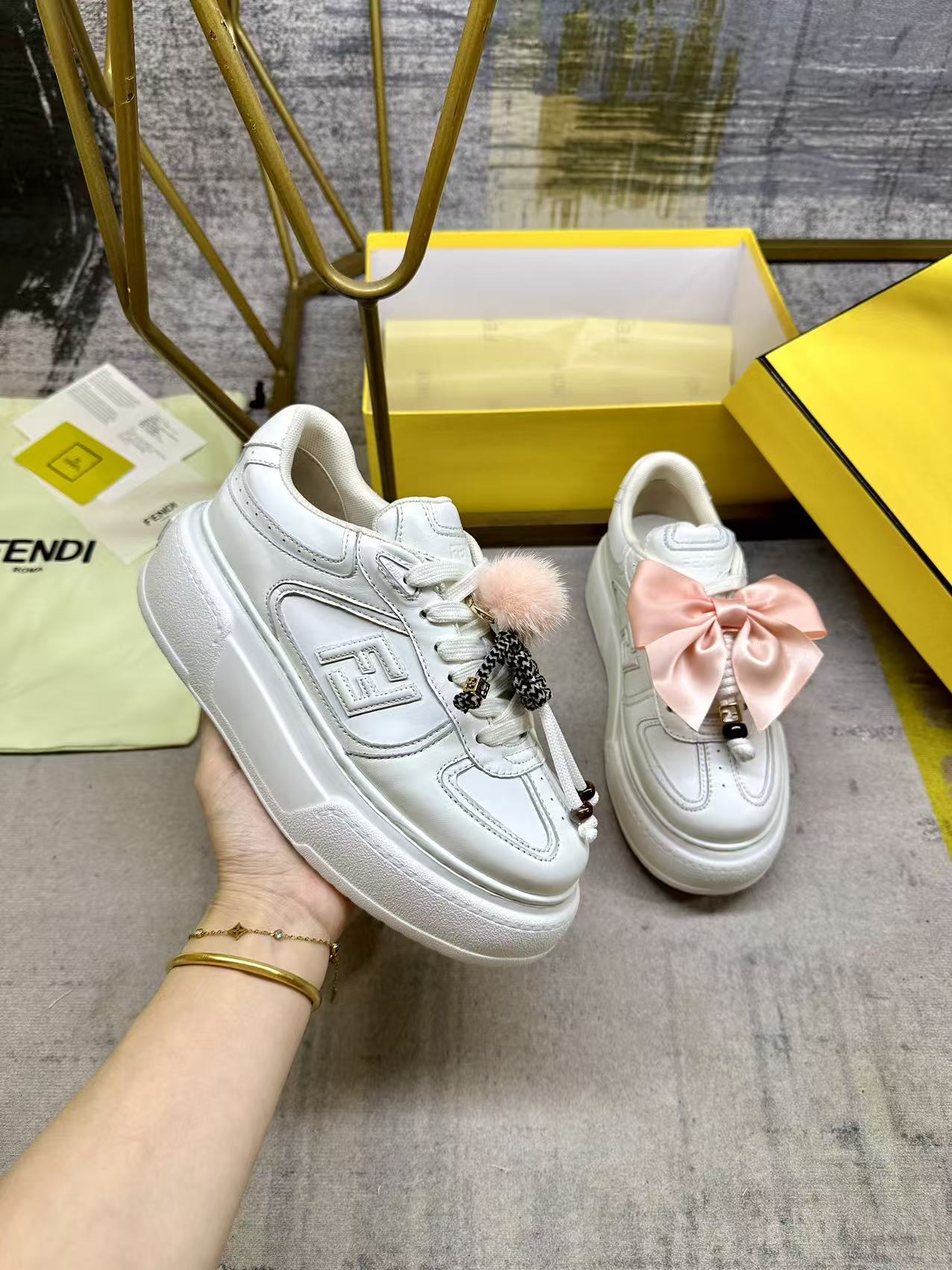 <p>FENDI Match系带运动鞋 白色皮革材质 侧面饰有同色系皮革FF贴花 配白色鞋带 橡胶厚鞋底 后跟处饰有超大凸纹FENDI字样 鞋舌上饰有金属环挂饰 右鞋上饰有带粉红色貂皮细节和金色金属FF图案手链的编绳小玩偶 左鞋上饰有配白色和粉红色绳索的大号粉红色塔夫绸蝴蝶结和金色金属FF和树脂玳瑁效果珠饰 玩偶可拆卸 35-42码</p>