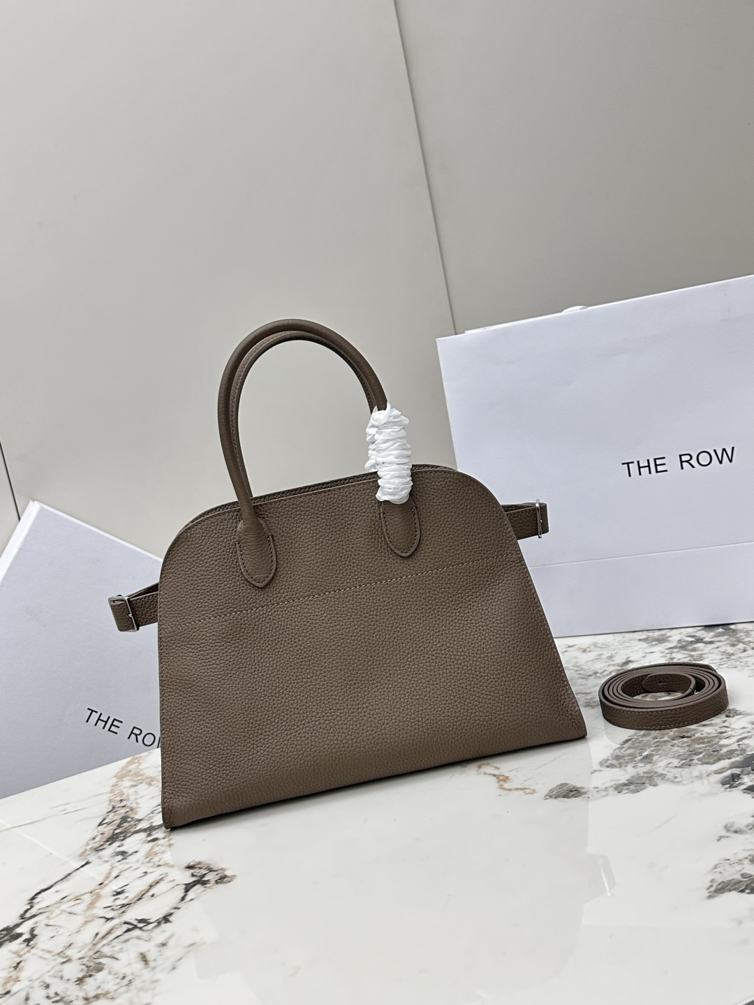 <p>荔枝纹 小号32CM The Row 专柜爆款经典托特包Soft Margaux 12寸系列 荔枝纹小牛皮 超大容量轻便手提包 简约而不张扬 采用全钢银色五金 包面采用进口荔枝纹牛皮 触感柔软极佳 束带风琴式侧面 内侧滑扣开合 一个拉链袋 两个插袋 配有一条肩带可斜挎哦 型号 T1586  尺寸 长32x宽19x高23cm </p>