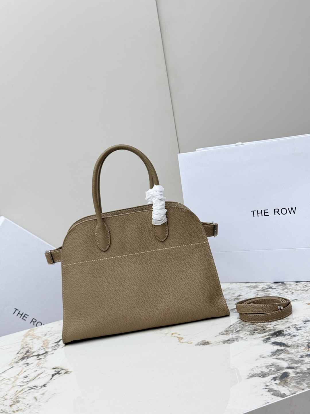 <p>荔枝纹 小号32CM The Row 专柜爆款经典托特包Soft Margaux 12寸系列 荔枝纹小牛皮 超大容量轻便手提包 简约而不张扬 采用全钢银色五金 包面采用进口荔枝纹牛皮 触感柔软极佳 束带风琴式侧面 内侧滑扣开合 一个拉链袋 两个插袋 配有一条肩带可斜挎哦 型号 T1586  尺寸 长32x宽19x高23cm </p>