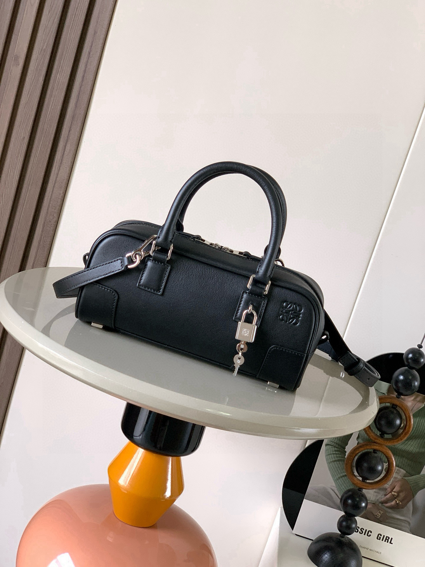 <p>新款明星同款手袋 Amazona 是 LOEWE 最初于1970年代推出的标志性手袋 采用精致比例和关键细节包括 Anagram 镌刻挂锁短款以纳帕牛皮革打造而成 可肩背 斜挎或手提 可拆卸可调节肩带 拉链开合 牛皮革拉链头 一个内部拉链隔层 一个插袋 一个挂锁钥匙收纳袋 包底以金属脚钉保护 金色绒面革衬里*款号 9085</p><p>颜色 黑色银锁</p>