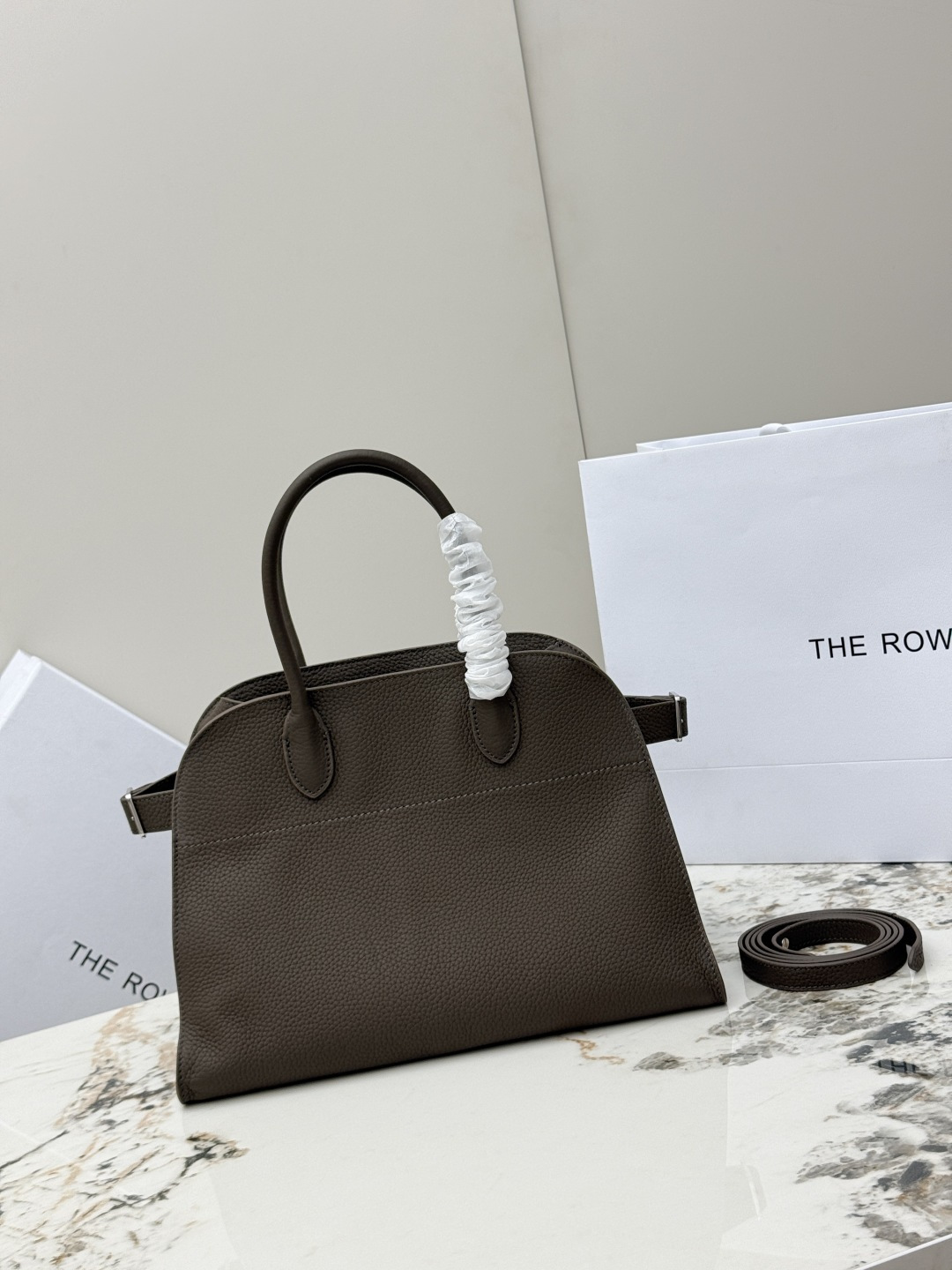 <p>荔枝纹 小号32CM The Row 专柜爆款经典托特包Soft Margaux 12寸系列 荔枝纹小牛皮 超大容量轻便手提包 简约而不张扬 采用全钢银色五金 包面采用进口荔枝纹牛皮 触感柔软极佳 束带风琴式侧面 内侧滑扣开合 一个拉链袋 两个插袋 配有一条肩带可斜挎哦 型号 T1586  尺寸 长32x宽19x高23cm </p>