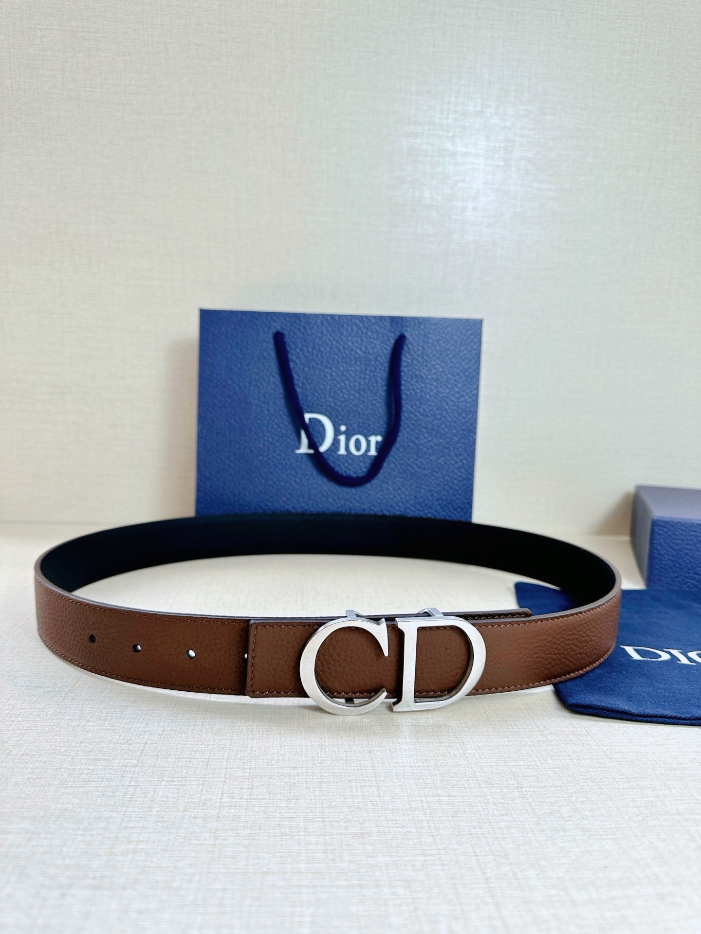 Dior 这款双面腰带结合典雅气质与摩登风范 双面均采用粒面牛皮革精心制作 一面为黑色 另一面为海军蓝色 可搭配各式 35 毫米腰带扣 更添精致 打造富有个性特色的配饰 时尚百搭 