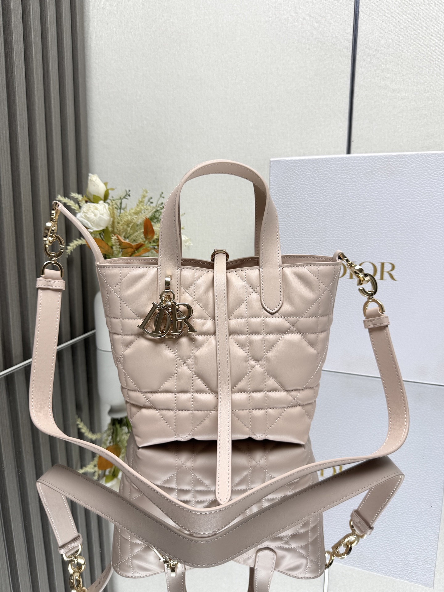 这款 Dior Toujours竖版手袋是二零二五早春成衣系列新品 时尚实用 别具一格 采用黑色牛皮革精心制作 饰以超大藤格纹缉面线 宽敞的内部隔层可收纳各种日常用品 设有纤细皮革系带开合 可安全收纳各种物品 另有CD Lock 字母D旋钮式扣环 可调节两侧 提升格调 小号款式 顶部皮革手柄搭配可拆卸的皮革肩带 可手提 肩背或斜挎主体:牛皮革里料:牛皮革尺寸 16×18×12cm 款号 2835 23867
