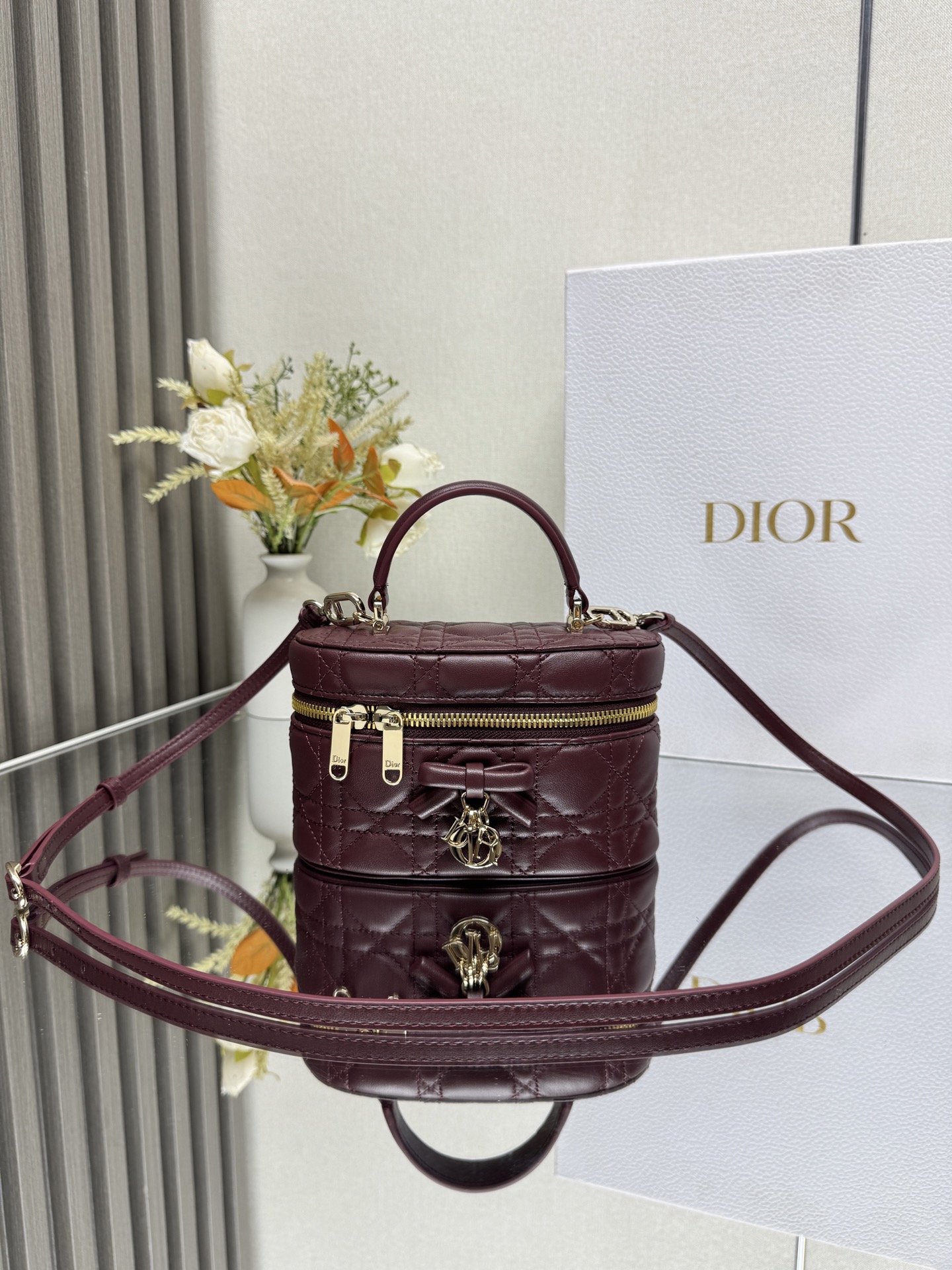 Dior 30 Montaigne 迷你 Vanity 蝴蝶手袋 酒红色羊皮 这款 30 Montaigne 迷你 Vanity 手袋设计精巧 兼具实用功能与高雅气质 为该系列提升格调 采用黑色羊皮菱格精心制作 内里配羊皮 正面饰以 CD 标志提升格调 可收纳各种日常用品 设有一个内部口袋和镜子 更显精致 可通过手柄手提 搭配同色可调节皮肩带 可肩背或斜挎 正面饰以 CD 标志拉链开合搭配 CD 拉链头顶部手柄1 个隔层内部贴袋可调节 可拆卸的皮革肩带型号 2603尺寸 17 x 8.5 x 11 厘米 长 x 高 x 宽 可收纳 1 部手机 1 个卡夹和唇膏23857