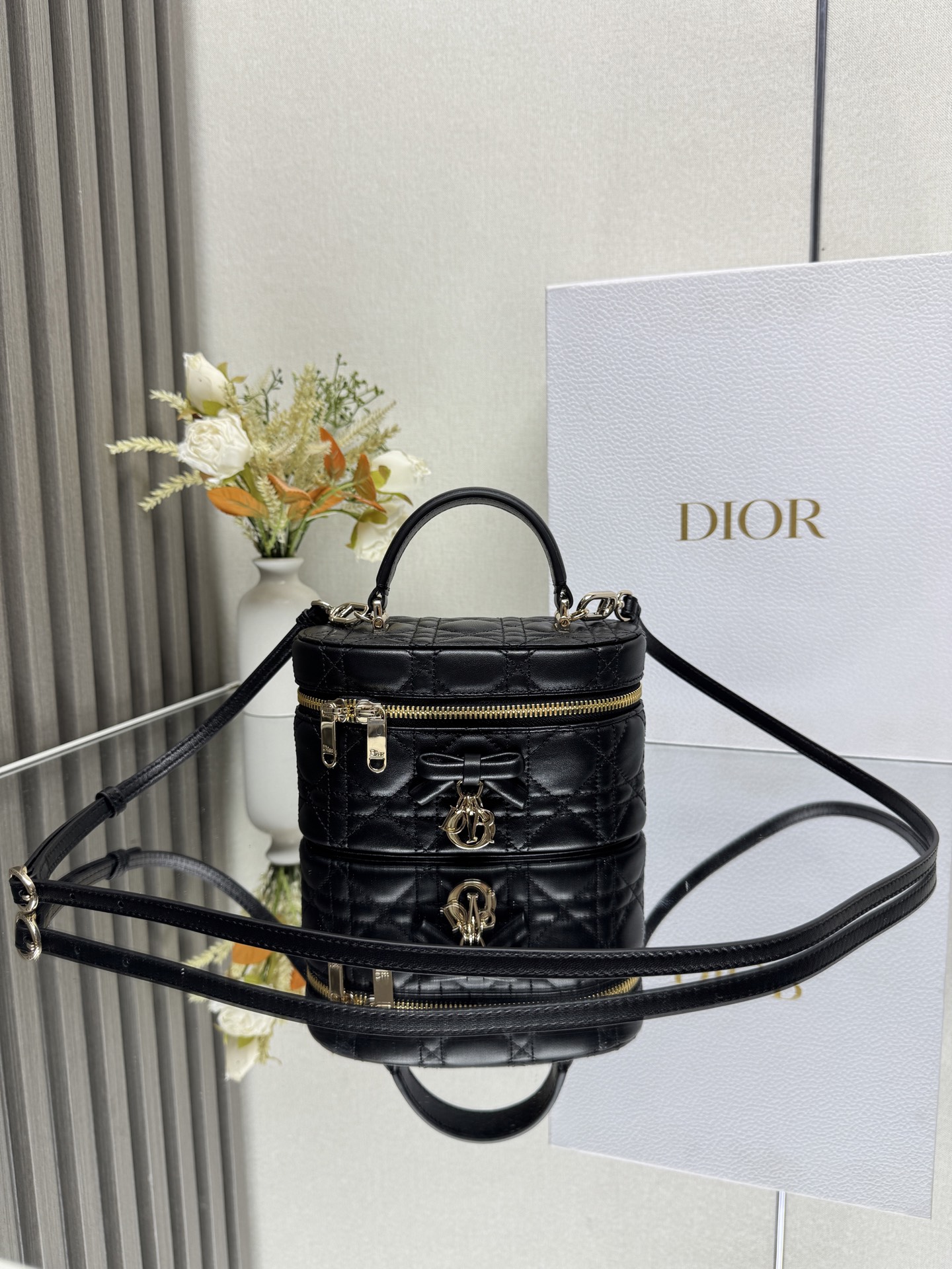 Dior 30 Montaigne 迷你 Vanity 蝴蝶手袋 黑色羊皮 这款 30 Montaigne 迷你 Vanity 手袋设计精巧 兼具实用功能与高雅气质 为该系列提升格调 采用黑色羊皮菱格精心制作 内里配羊皮 正面饰以 CD 标志提升格调 可收纳各种日常用品 设有一个内部口袋和镜子 更显精致 可通过手柄手提 搭配同色可调节皮肩带 可肩背或斜挎 正面饰以 CD 标志拉链开合搭配 CD 拉链头顶部手柄1 个隔层内部贴袋可调节 可拆卸的皮革肩带型号 2603尺寸 17 x 8.5 x 11 厘米 长 x 高 x 宽 可收纳 1 部手机 1 个卡夹和唇膏23857