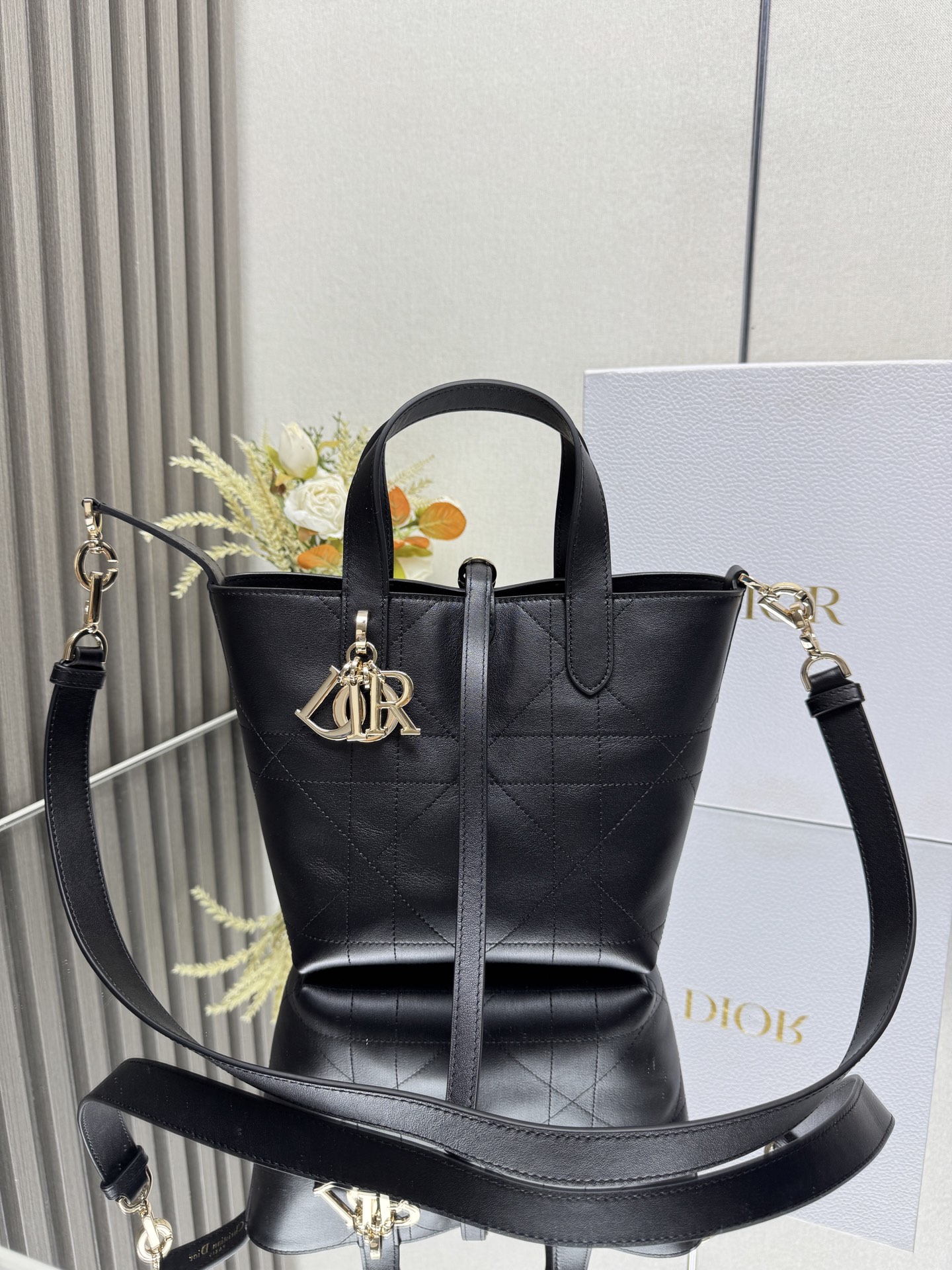  小号 Dior Toujours 竖版手袋 山羊纹黑色 这款 Dior Toujours 竖版手袋时尚实用 别具一格 采用黑色牛皮革精心制作 饰以超大藤格纹缉面线 宽敞的内部隔层可收纳各种日常用品 设有纤细皮革系带开合 可安全收纳各种物品 另有 CD Lock 字母 D 旋钮式扣环 可调节两侧 提升格调 小号款式 顶部皮革手柄搭配可拆卸的皮革肩带 可手提 肩背或斜挎 双开合设计 纤细系带和 Christian Dior Paris 系带搭配 CD Lock 扣环 D.I.O.R. 吊饰内部插袋可放置卡片顶部皮革手柄可拆卸皮革肩带型号 2835
