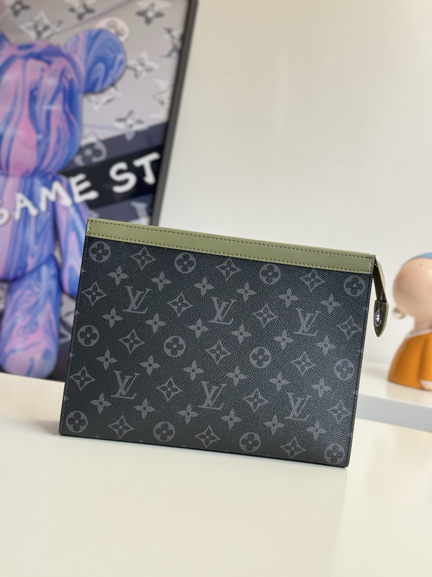   海外原单M28841独家实拍 本款 Pochette Voyage 手拿包汲取 2000 年代日本街头风格 为 Monogram Eclipse 帆布搭配皮革上缘和可水洗内衬 多重卡位和贴袋共筑齐整内部空间 可轻松携带或置入旅行袋存放物品 尺寸 33.5×26×5.5cm
