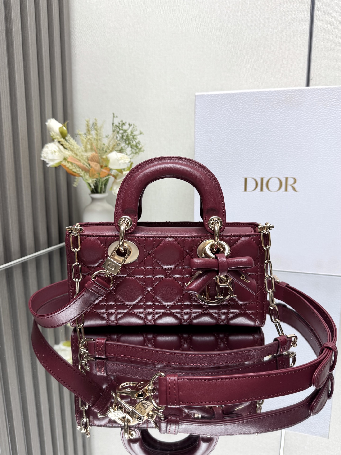 小号 LADY D-JOY 手袋 枣红色带蝴蝶结小羊皮 这款 Lady D-Joy 手袋凸显 Lady Dior 系列的简约美学 集中体现了 Dior 对典雅和美丽的深刻洞见 采用黑色哑光牛皮革精心制作 以经典的藤格纹缉面线打造醒目的绗缝细节 精良的缝制工艺显露无遗 同色调金属 D.I.O.R. 吊饰彰显优雅气质 小号款式 搭配可拆卸的链条肩带和可调节 可拆卸的皮革肩带 可手提 肩背或斜挎 是日常造型的理想之选可拆卸链条肩带可拆卸 可调节的皮革肩带型号 0613尺寸 22 x 12 x 6 cm238600
