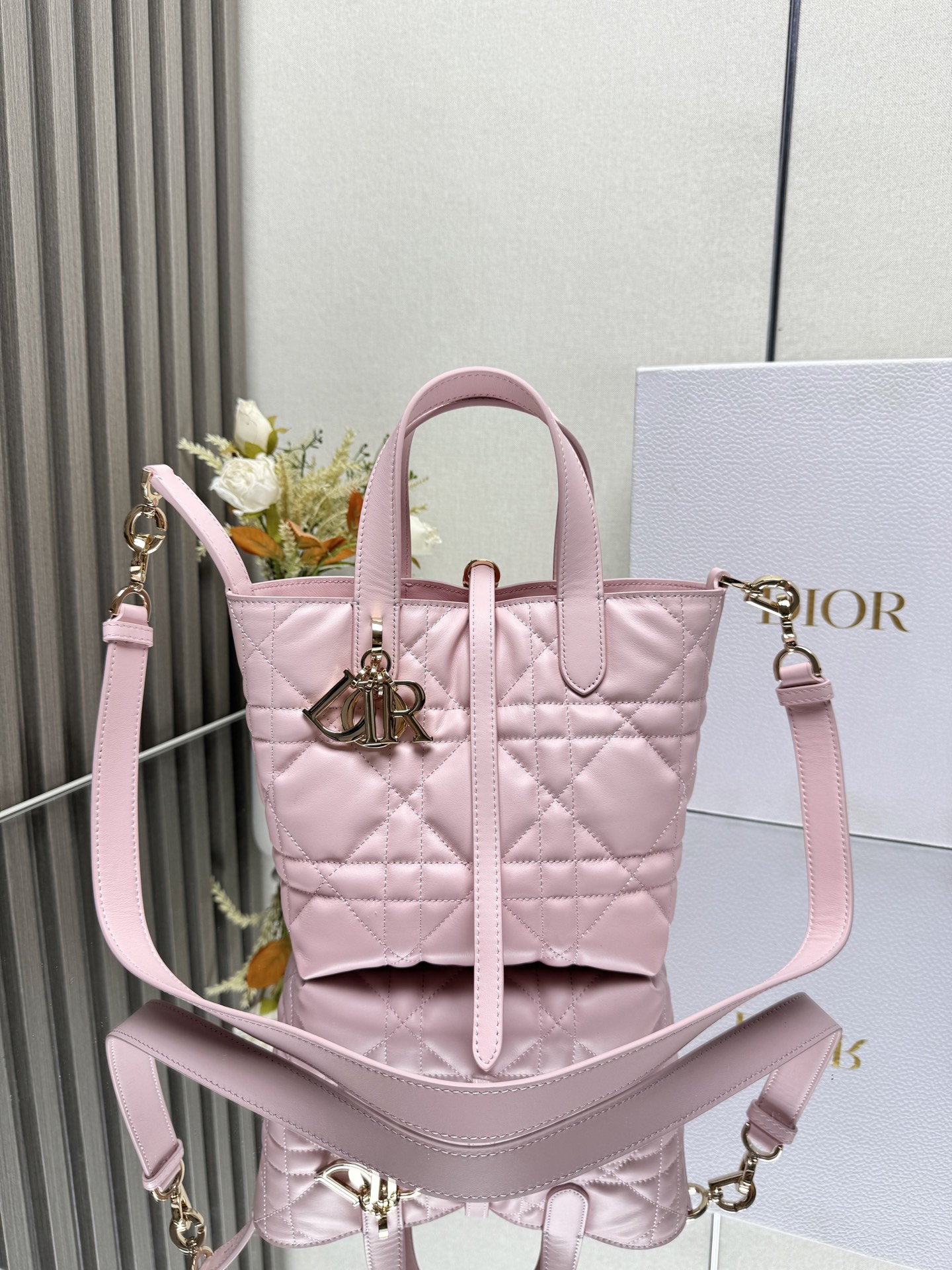 这款 Dior Toujours竖版手袋是二零二五早春成衣系列新品 时尚实用 别具一格 采用黑色牛皮革精心制作 饰以超大藤格纹缉面线 宽敞的内部隔层可收纳各种日常用品 设有纤细皮革系带开合 可安全收纳各种物品 另有CD Lock 字母D旋钮式扣环 可调节两侧 提升格调 小号款式 顶部皮革手柄搭配可拆卸的皮革肩带 可手提 肩背或斜挎主体:牛皮革里料:牛皮革尺寸 16×18×12cm 款号 2835 23867