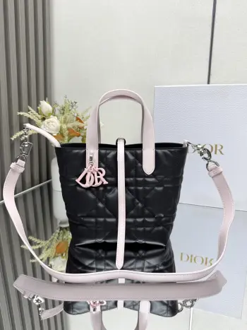 这款 Dior Toujours竖版手袋是二零二五早春成衣系列新品 时尚实用 别具一格 采用黑配粉色牛皮革精心制作 饰以超大藤格纹缉面线 宽敞的内部隔层可收纳各种日常用品 设有纤细皮革系带开合 可安全收纳各种物品 另有CD Lock 字母D旋钮式扣环 可调节两侧 提升格调 小号款式 顶部皮革手柄搭配可拆卸的皮革肩带 可手提 肩背或斜挎主体:牛皮革里料:牛皮革尺寸 16×18×12cm 款号 2835