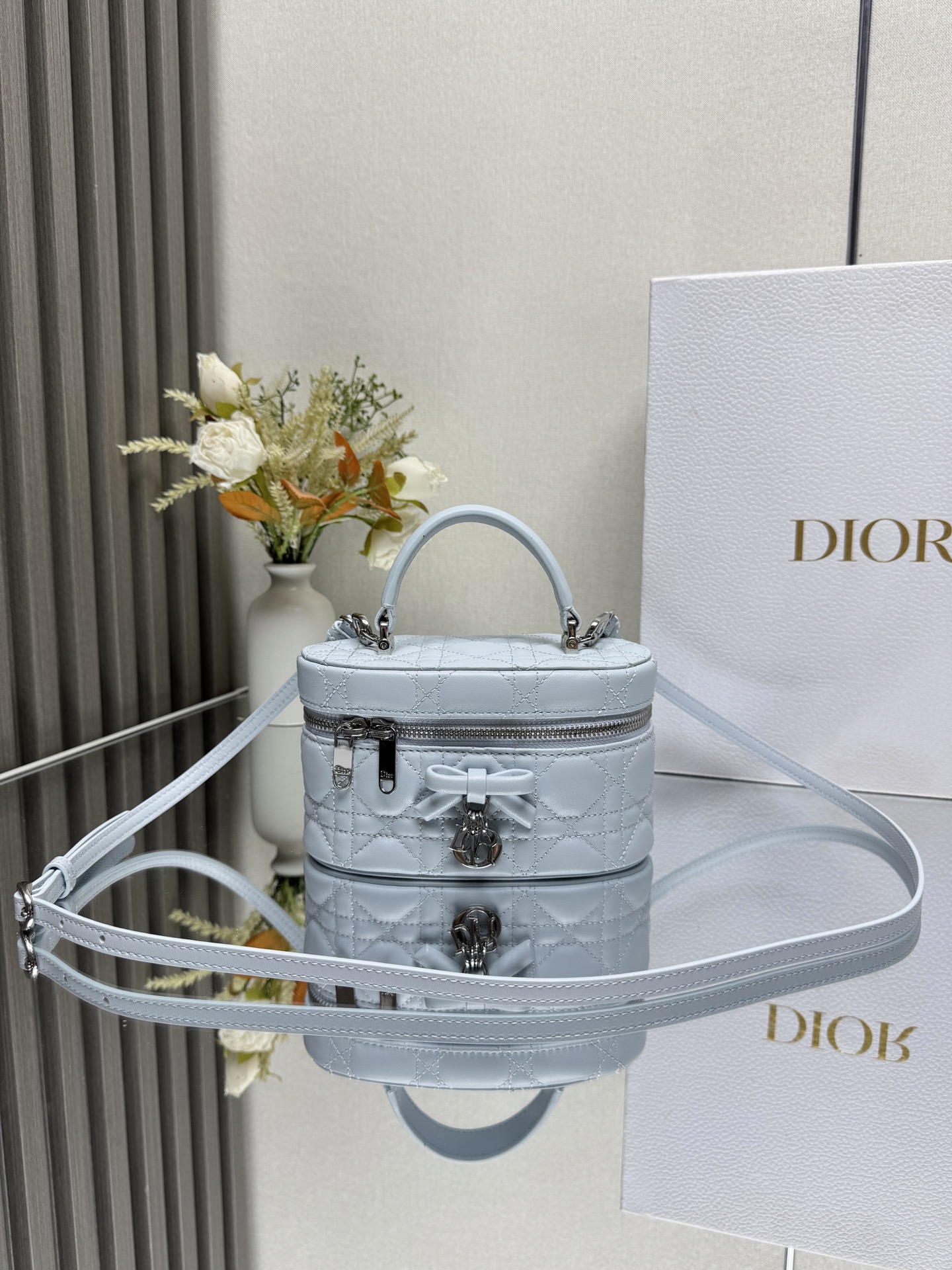 Dior 30 Montaigne 迷你 Vanity 蝴蝶手袋 蓝色羊皮 这款 30 Montaigne 迷你 Vanity 手袋设计精巧 兼具实用功能与高雅气质 为该系列提升格调 采用黑色羊皮菱格精心制作 内里配羊皮 正面饰以 CD 标志提升格调 可收纳各种日常用品 设有一个内部口袋和镜子 更显精致 可通过手柄手提 搭配同色可调节皮肩带 可肩背或斜挎 正面饰以 CD 标志拉链开合搭配 CD 拉链头顶部手柄1 个隔层内部贴袋可调节 可拆卸的皮革肩带型号 2603尺寸 17 x 8.5 x 11 厘米 长 x 高 x 宽 可收纳 1 部手机 1 个卡夹和唇膏23857