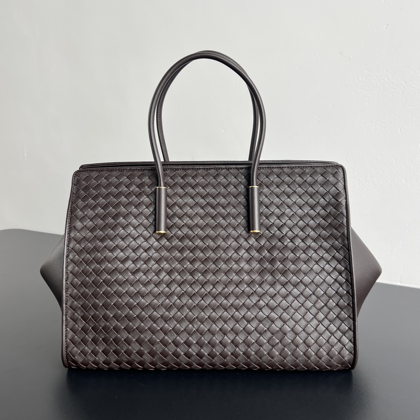 BV新品 Barbare Tote手袋   868327  精致的简约风格 是一种安静的高级感 柔软的小羊皮在匠人手中被编织成细密的纹理 摸上去温润又丝滑 包包两侧可敞开展随性 也可收拢变正式托特包 方正的包型即能容纳下13寸电脑 文件衣物都能装下 硬挺版型+舒适提手 能hold住正式场合 也能适配日常通勤 真正做到 一包装下所有场合 是职场大女主的气场担当 尺寸 37x27x24