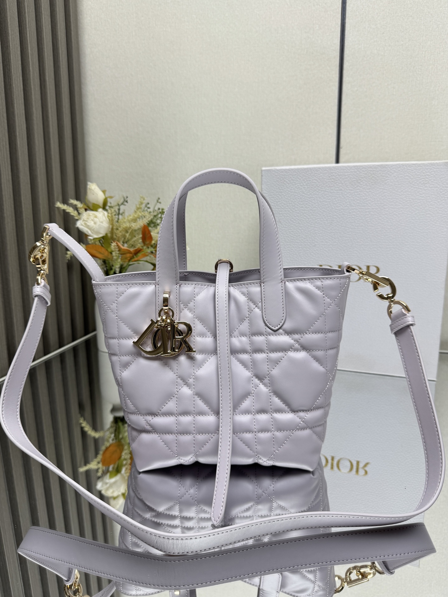 这款 Dior Toujours竖版手袋是二零二五早春成衣系列新品 时尚实用 别具一格 采用冰川蓝色牛皮革精心制作 饰以超大藤格纹缉面线 宽敞的内部隔层可收纳各种日常用品 设有纤细皮革系带开合 可安全收纳各种物品 另有CD Lock 字母D旋钮式扣环 可调节两侧 提升格调 小号款式 顶部皮革手柄搭配可拆卸的皮革肩带 可手提 肩背或斜挎主体:牛皮革里料:牛皮革尺寸 16×18×12cm 款号 2835