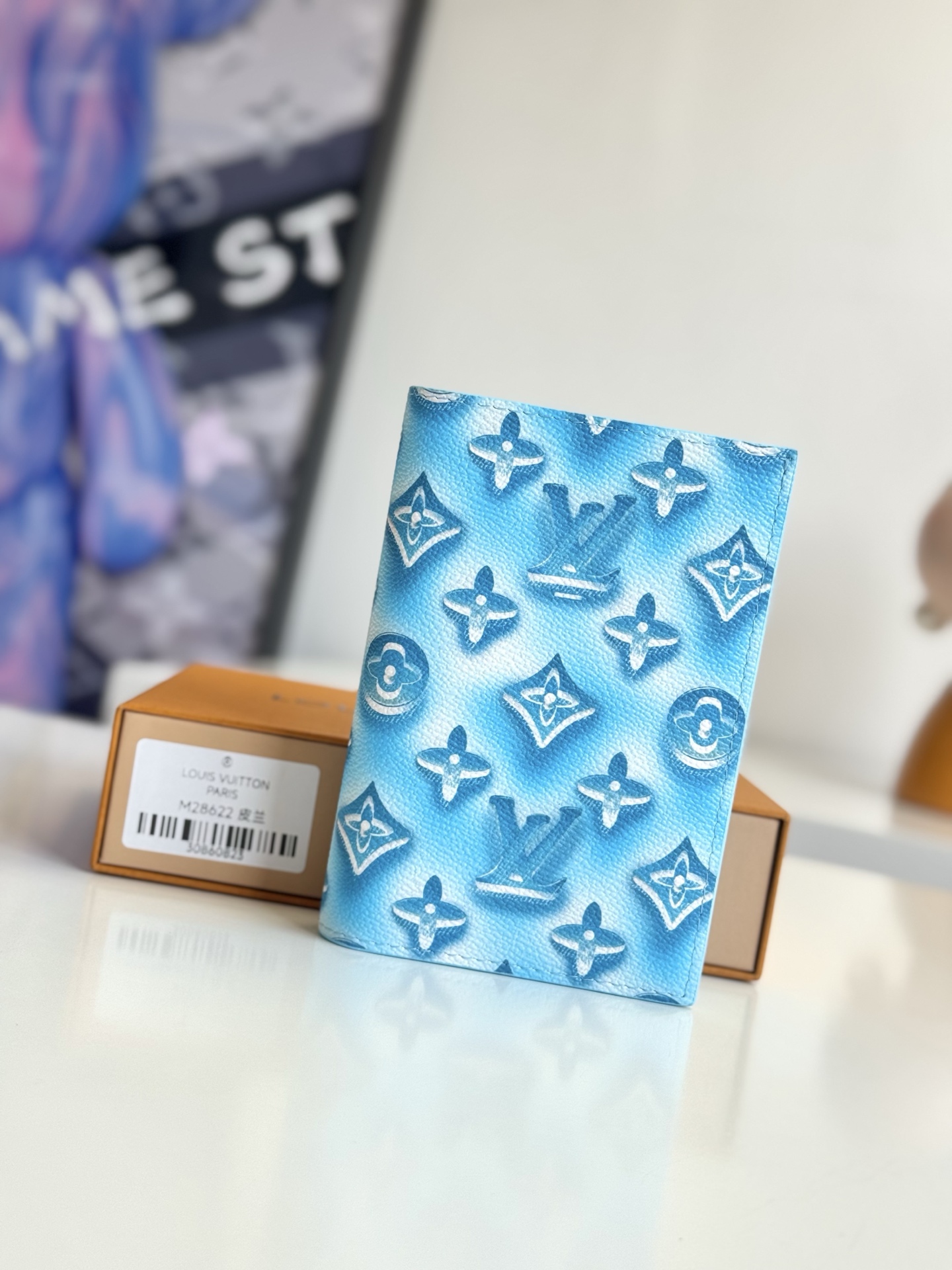   海外原单M28622蓝独家实拍  Monogram Ice Cube画布上添加了色彩缤纷的图案 标志性的护照封面 Couvertle Passport  像冰块给饮料带来清凉感和风味一样 融合了活力感和庄园般的设计 内饰采用色调皮革 设有四个卡槽 一个平口袋和两个开放式护照舱 尺寸 14×10×2.5cm