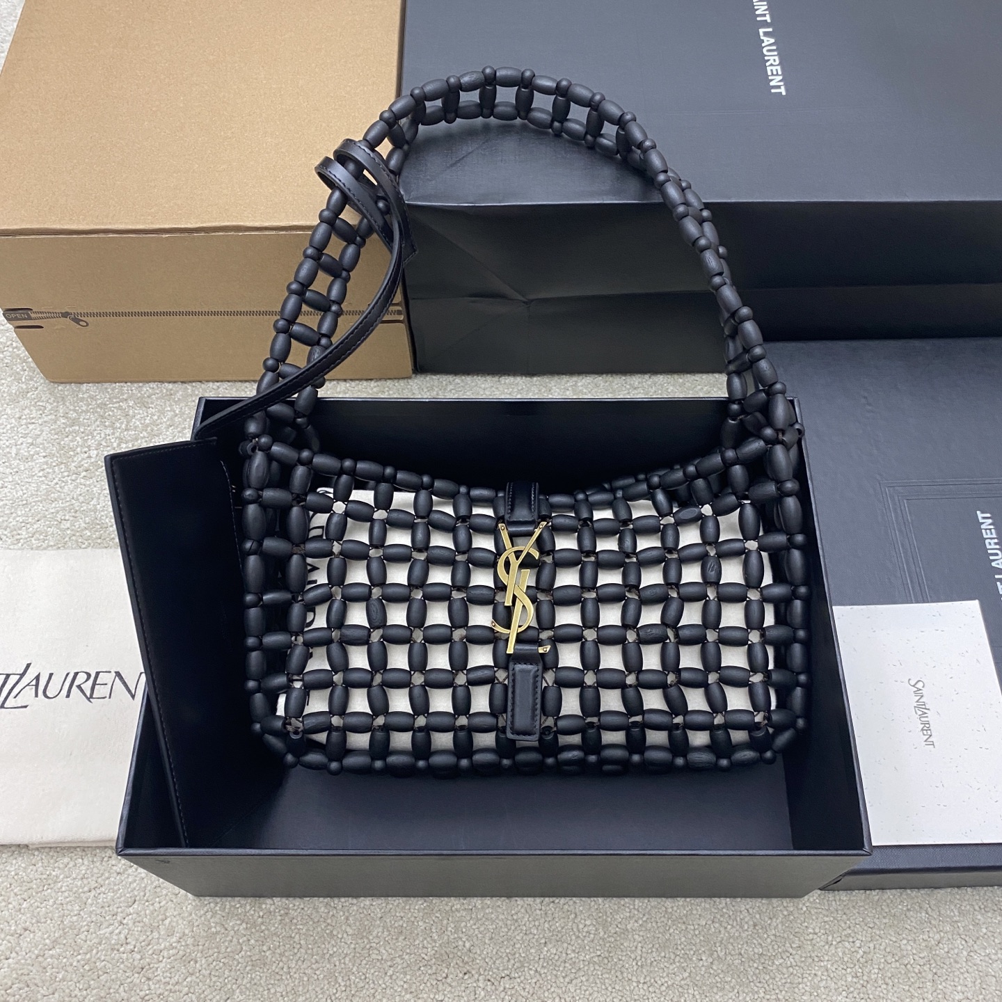 黑木珠/金YSL LE 5A7腋下包 手工串珠 采用椭圆形木珠手工编织 质感独特 触感温暖 正面金色YSL金属标志超有辨识度 Hobo弧形包型 轻盈能装 通勤约会都OK!肩带可调节 手提or腋下背都时髦,黑金配色百搭 裙装西装都能轻松驾驭 是实用又高级的时尚单品 型号 657228 尺寸 23x16x6.5cm